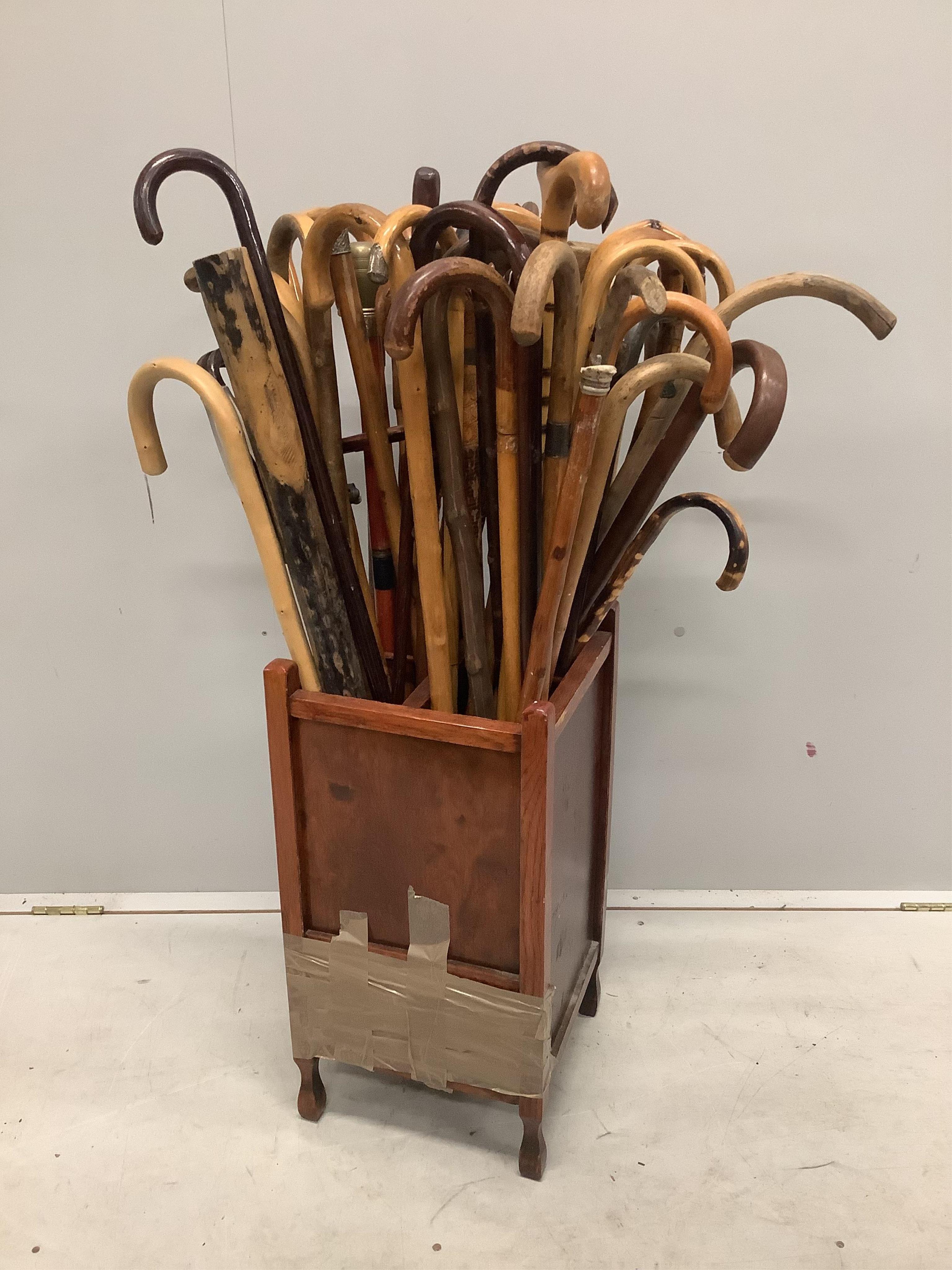 A large collection of assorted walking and shooting sticks in four division stick stand. Condition - fair, stand poor